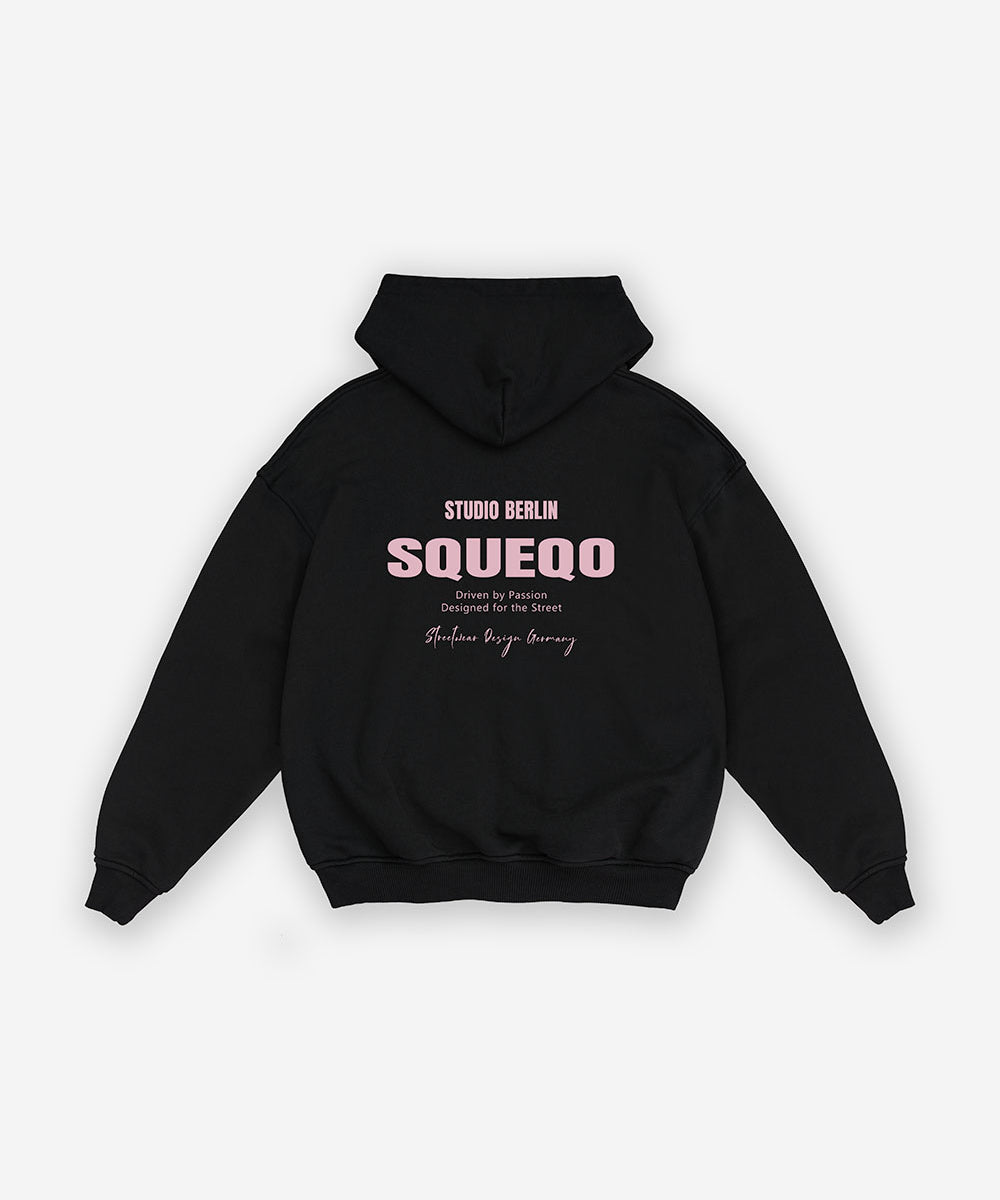 Schwarzer Oversize Zip Hoodie mit Print in hellrosa "Studio Berlin", Rückansicht.