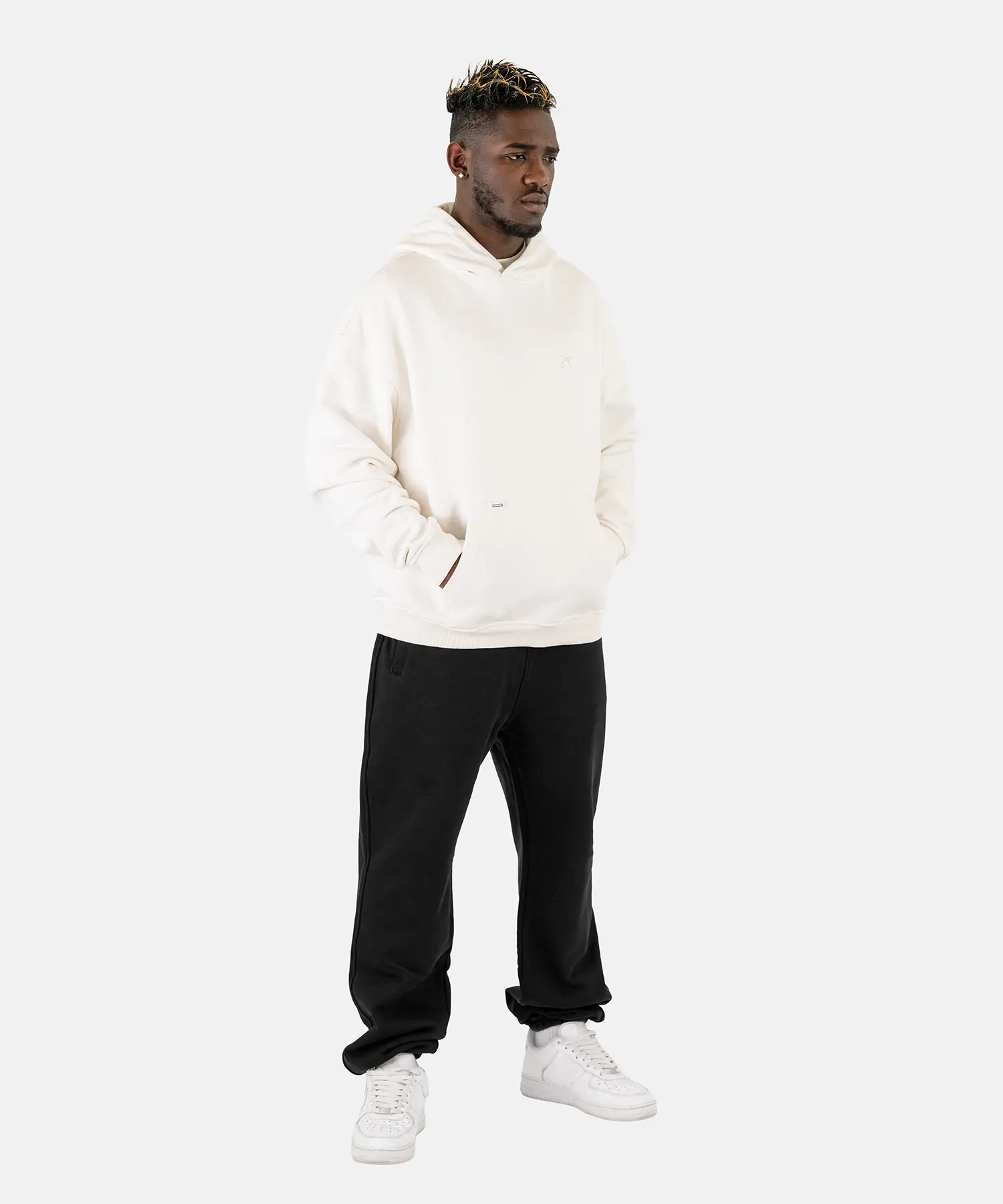 Ein männliches Model trägt den Squeqo Zip Hoodie in Off-White als Teil eines lässigen Streetwear-Looks.