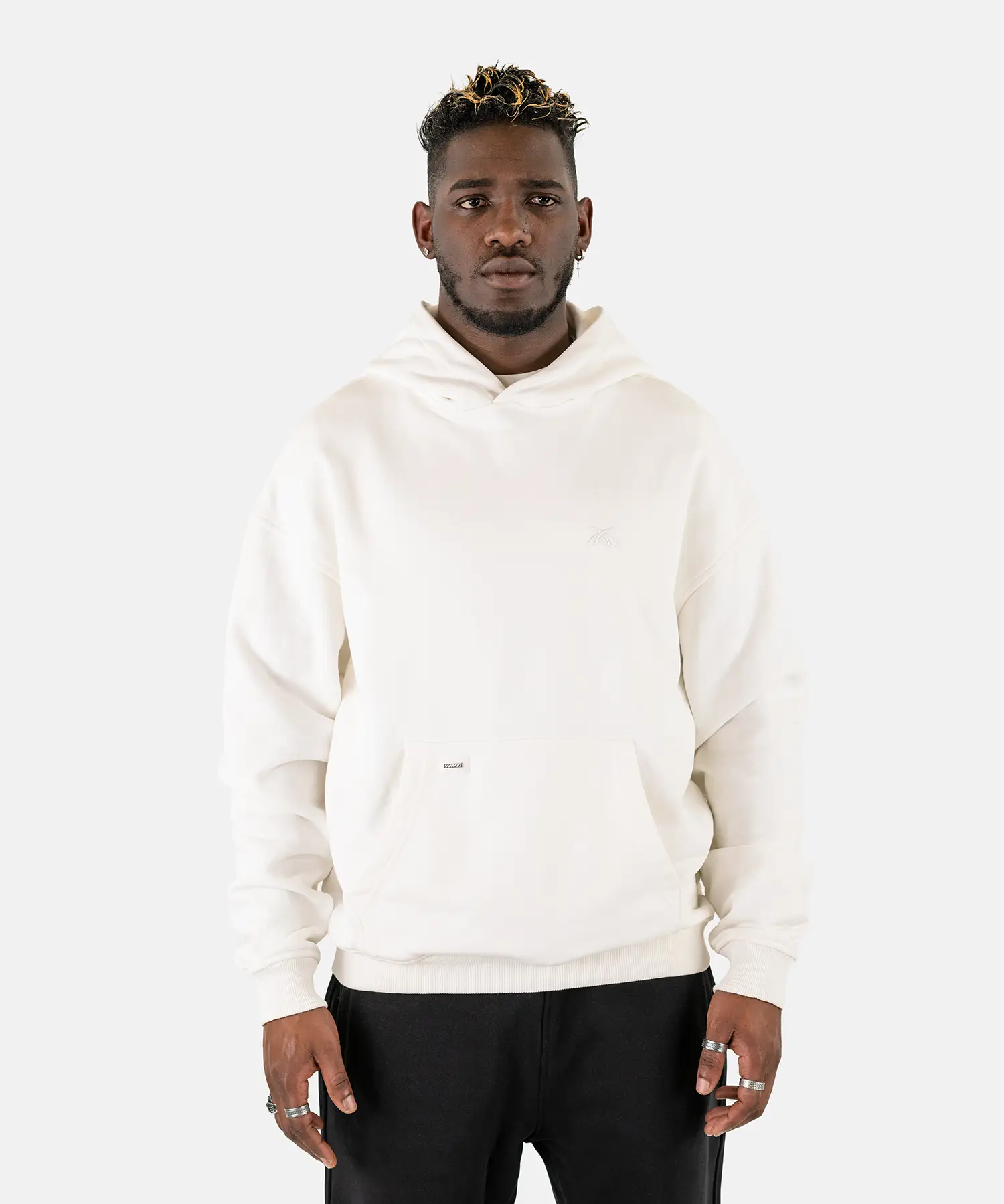 Vorderansicht eines männlichen Models, das den Squeqo Essential Oversized Hoodie in Off-White trägt.