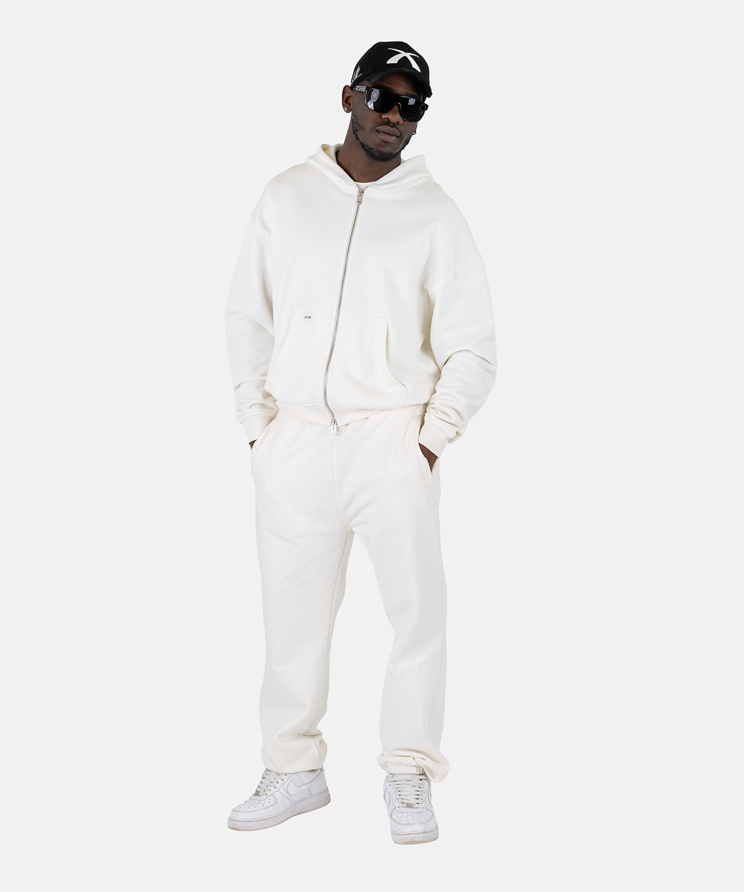 Ein männliches Model trägt den Squeqo Zip Hoodie in Off-White als Teil eines lässigen Streetwear-Looks.