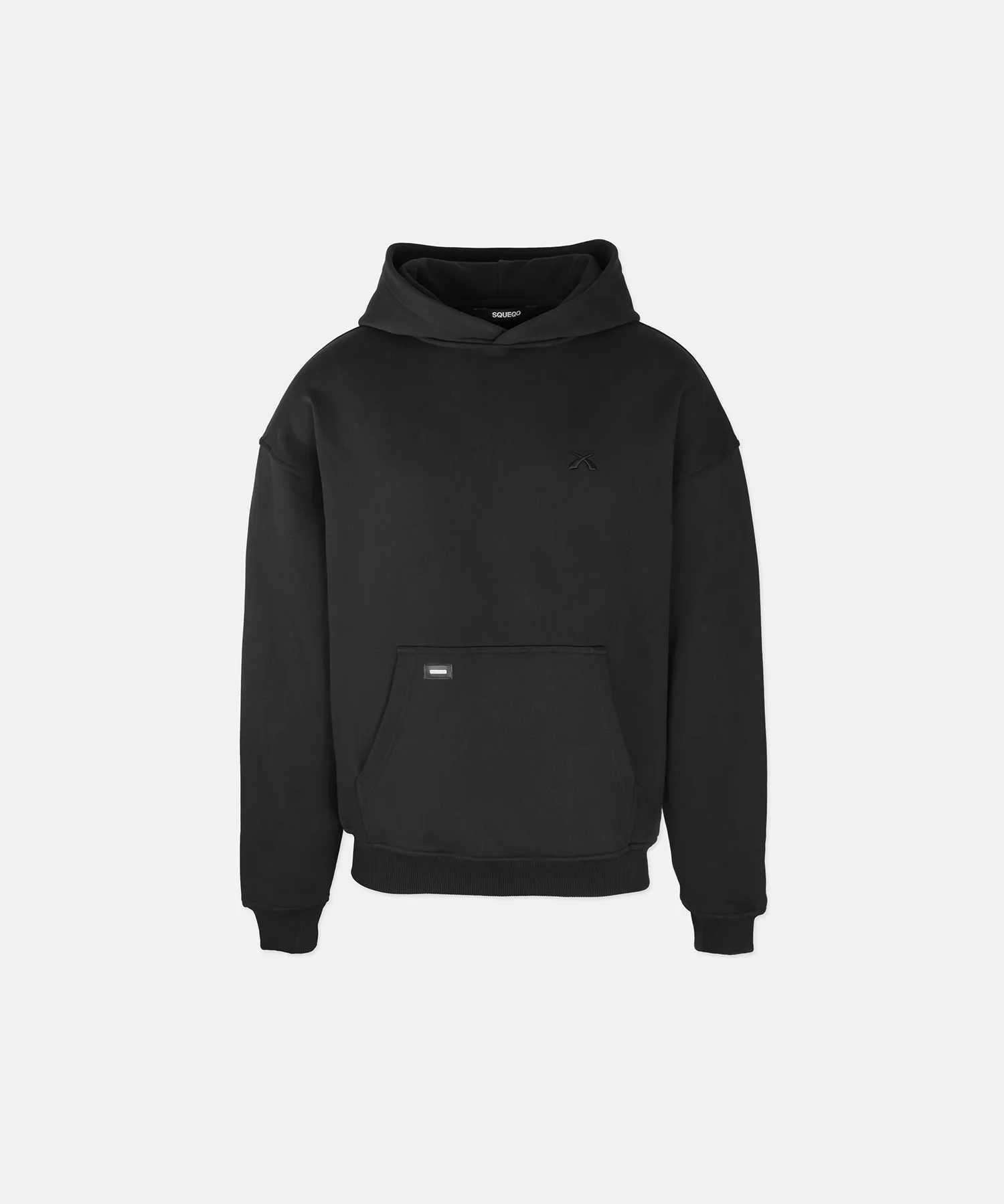 Freigestelltes Produktfoto des schwarzen SQUEQO Oversized Hoodies. Die kastenförmige Passform, die große Kapuze ohne Kordelzug und die Kängurutasche sind klar erkennbar.