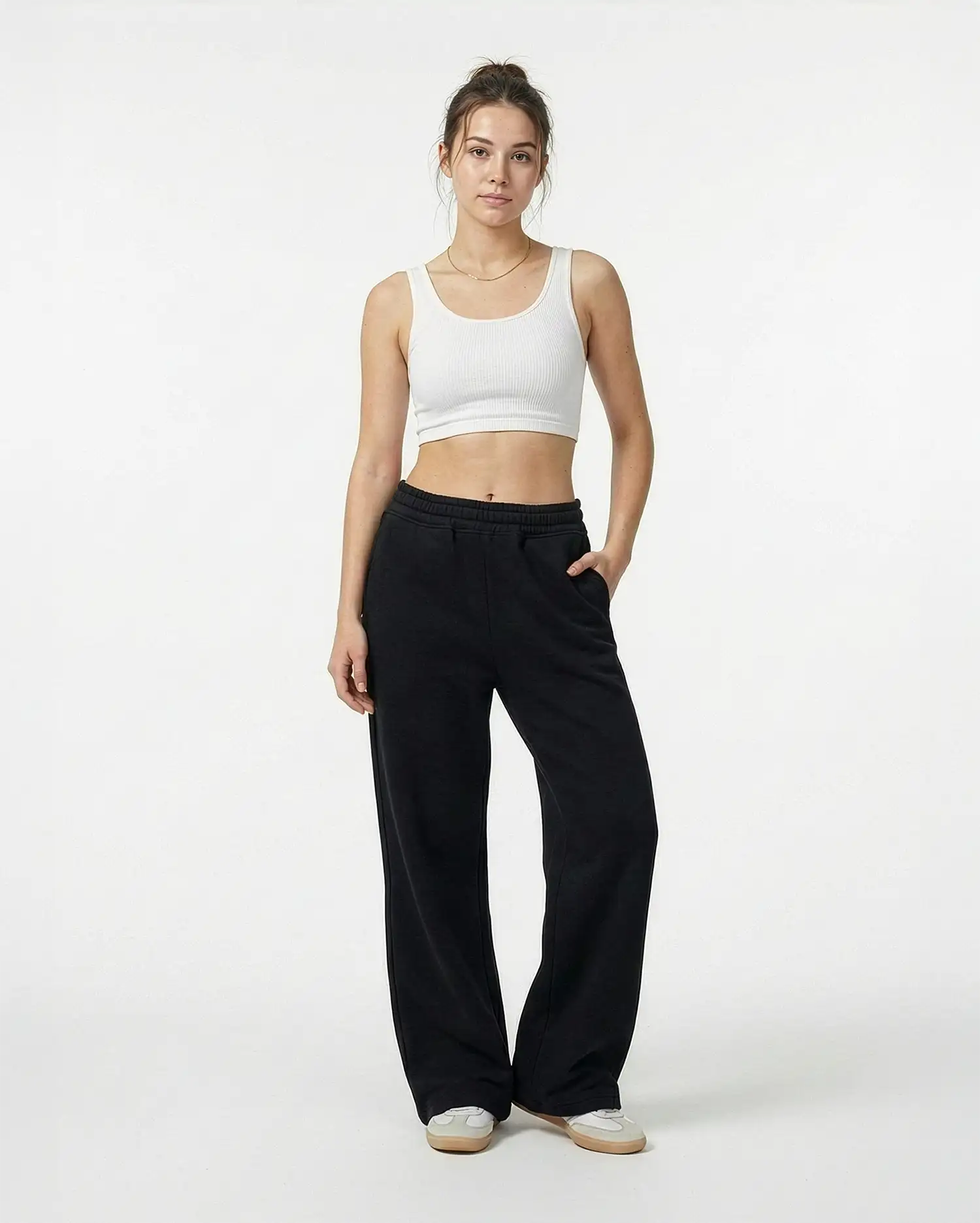 Model trägt die schwarze Elodie Sweatpant im Stacked-Look mit Extra-Länge und typischem Faltenwurf am Knöchel.