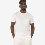 Ein männliches Model trägt das Squeqo Basic T-Shirt mit Brusttasche in Off-White und zeigt die Passform des Shirts.