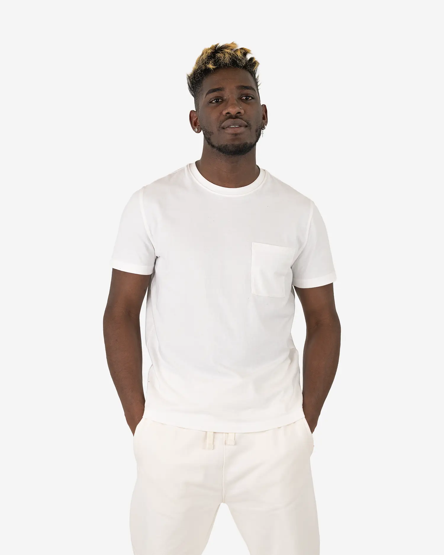 Ein männliches Model trägt das Squeqo Basic T-Shirt mit Brusttasche in Off-White und zeigt die Passform des Shirts.