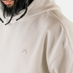 Detailaufnahme der überschnittenen Schulternaht und des gestickten Logos am Squeqo Essential Oversized Hoodie.