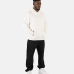 Ein männliches Model trägt den Squeqo Zip Hoodie in Off-White als Teil eines lässigen Streetwear-Looks.