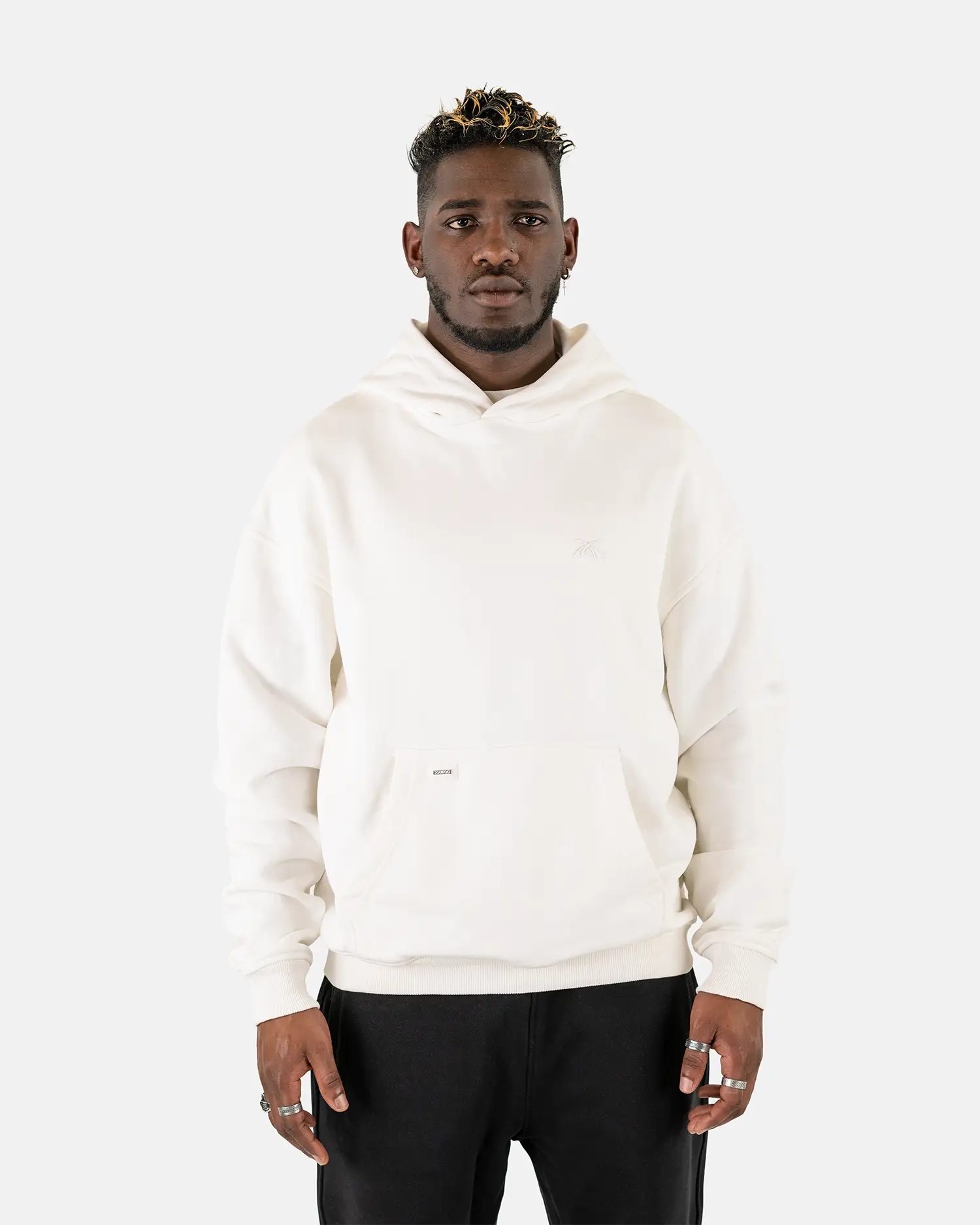 Vorderansicht eines männlichen Models, das den Squeqo Essential Oversized Hoodie in Off-White trägt.