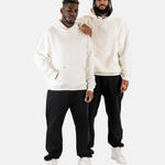 Zwei männliche Models tragen den Squeqo Essential Oversized Hoodie in Off-White zu schwarzen Hosen.