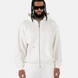 Vorderansicht eines männlichen Models, das den Squeqo Essential Oversized Zip Hoodie in Off-White trägt.