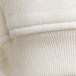 Detailaufnahme der elastischen Rippbündchen am Saum des Squeqo Zip Hoodies aus Baumwolle.