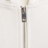 Nahaufnahme des YKK Zwei-Wege-Reißverschlusses mit Squeqo-Logo am Essential Zip Hoodie.