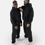 Zwei Models tragen den SQUEQO Oversized Hoodie in Schwarz und demonstrieren die vielseitige Unisex-Passform und moderne Styling-Möglichkeiten.