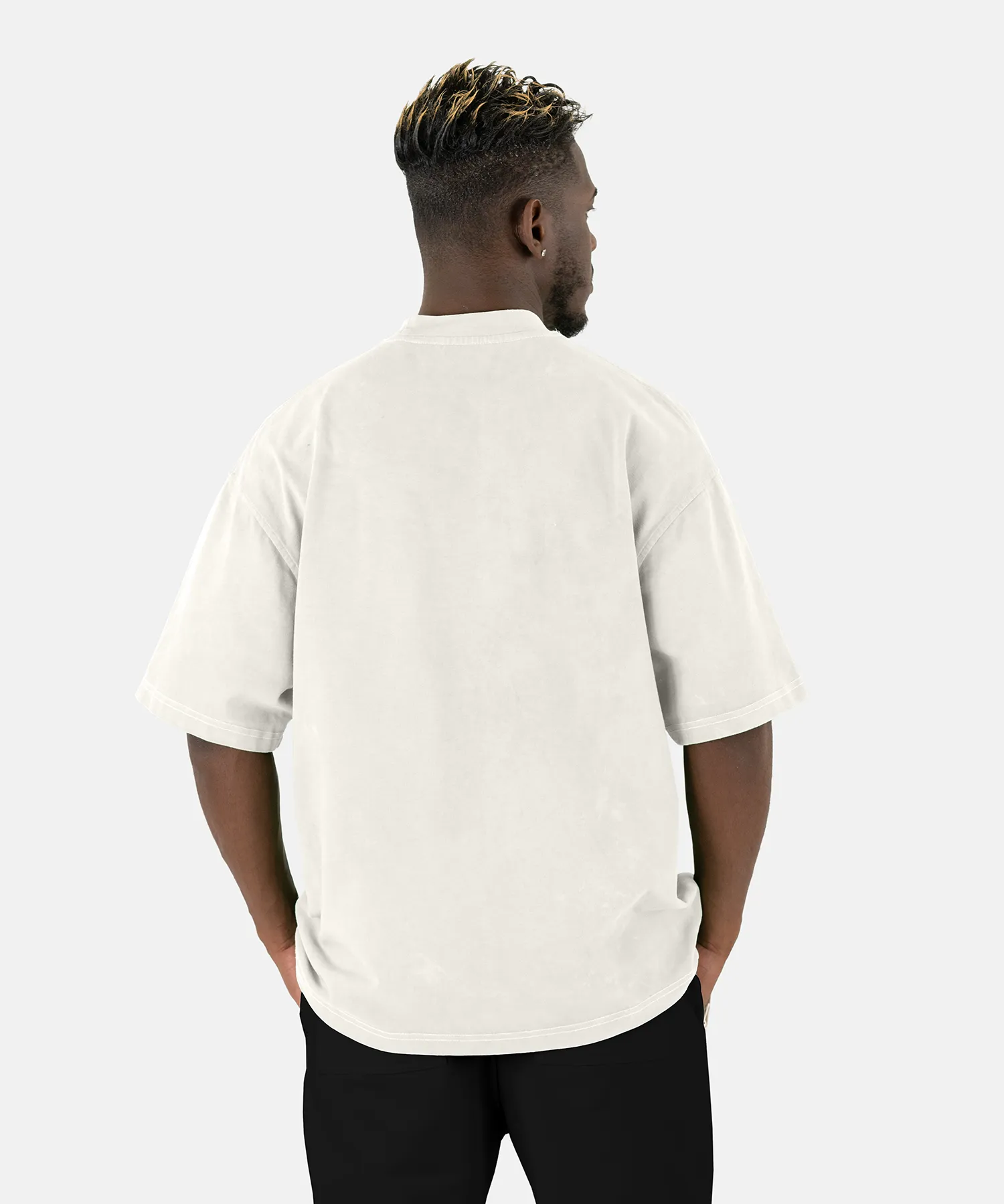 Rückenansicht eines männlichen Models, das das SQUEQO Oversized T-Shirt in Off-White trägt und die weite Oversized-Passform zeigt.