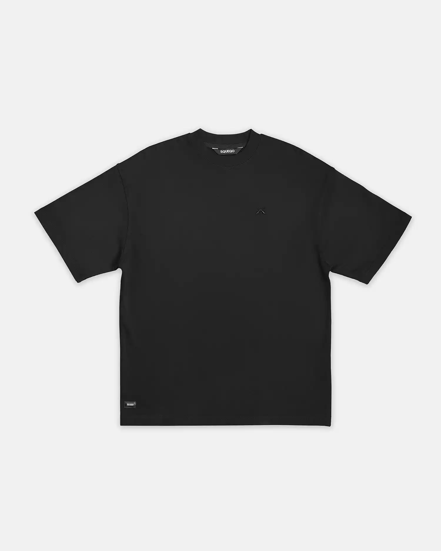 Flachgelegtes SQUEQO Oversized T-Shirt in Schwarz, das die Gesamtform, den weiten Schnitt und das Nackenlabel klar darstellt.