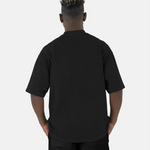 Rückenansicht eines Models, das das schwarze SQUEQO Oversized T-Shirt trägt und die weite Oversized-Passform zeigt.