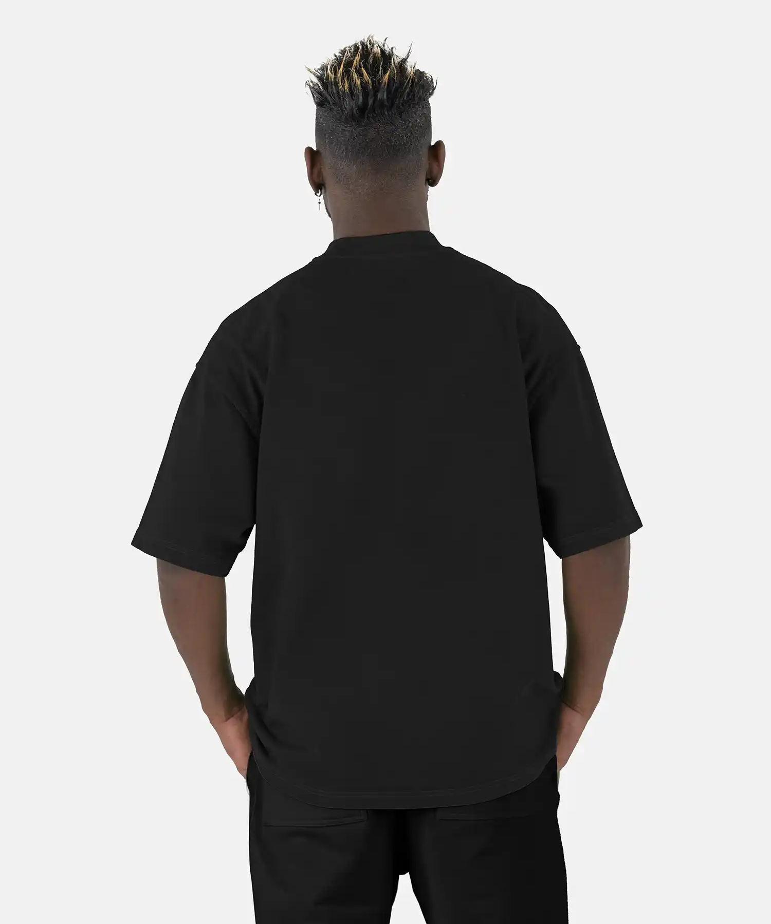 Rückenansicht eines Models, das das schwarze SQUEQO Oversized T-Shirt trägt und die weite Oversized-Passform zeigt.