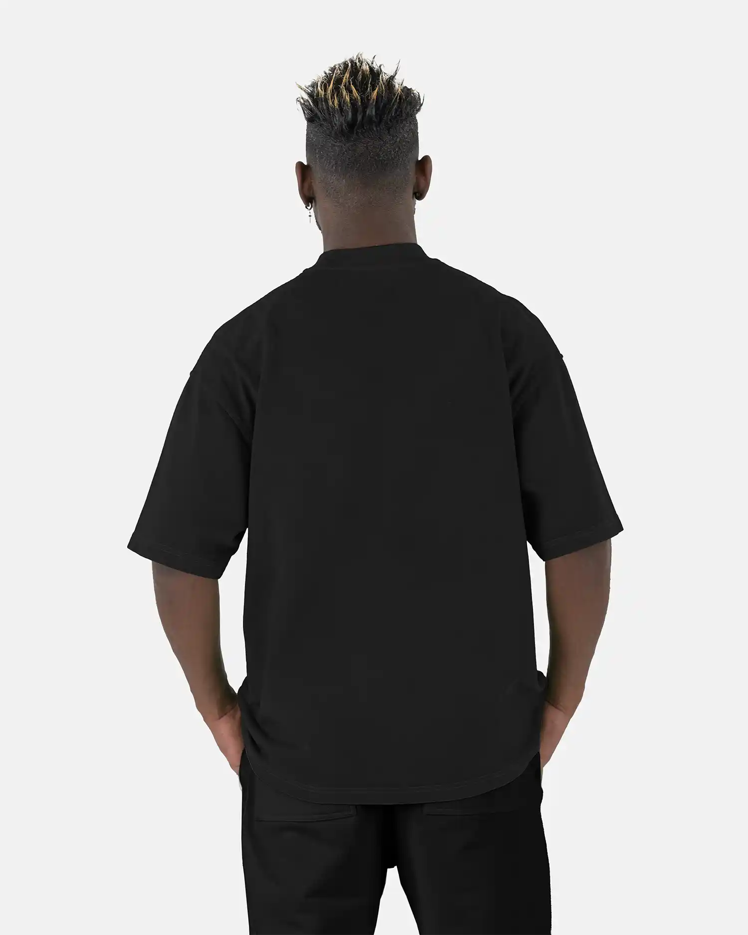 Rückenansicht eines Models, das das schwarze SQUEQO Oversized T-Shirt trägt und die weite Oversized-Passform zeigt.