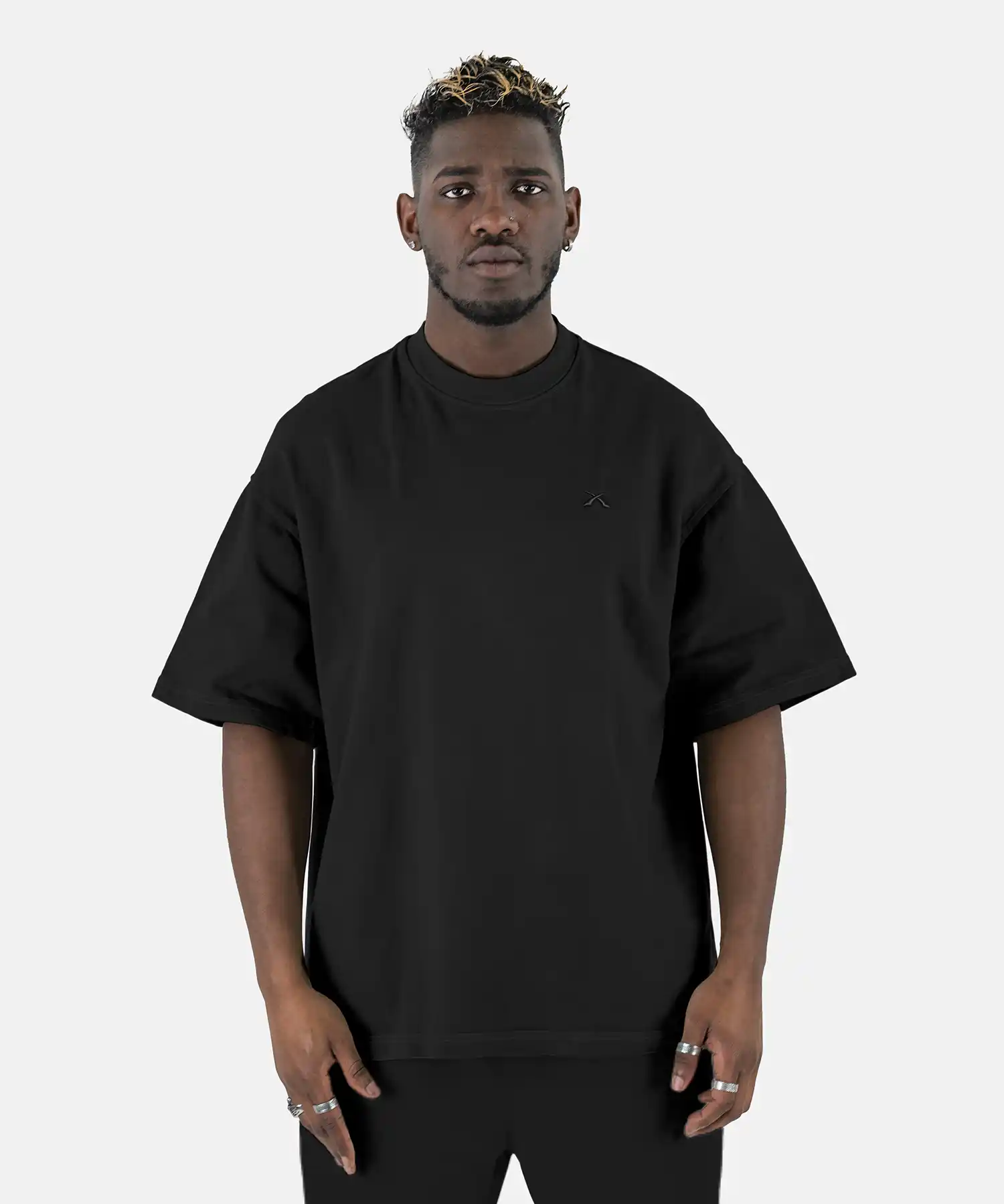 Vorderansicht eines Models, das das schwarze SQUEQO Oversized T-Shirt mit dezentem, Ton-in-Ton gesticktem Logo auf der Brust trägt.