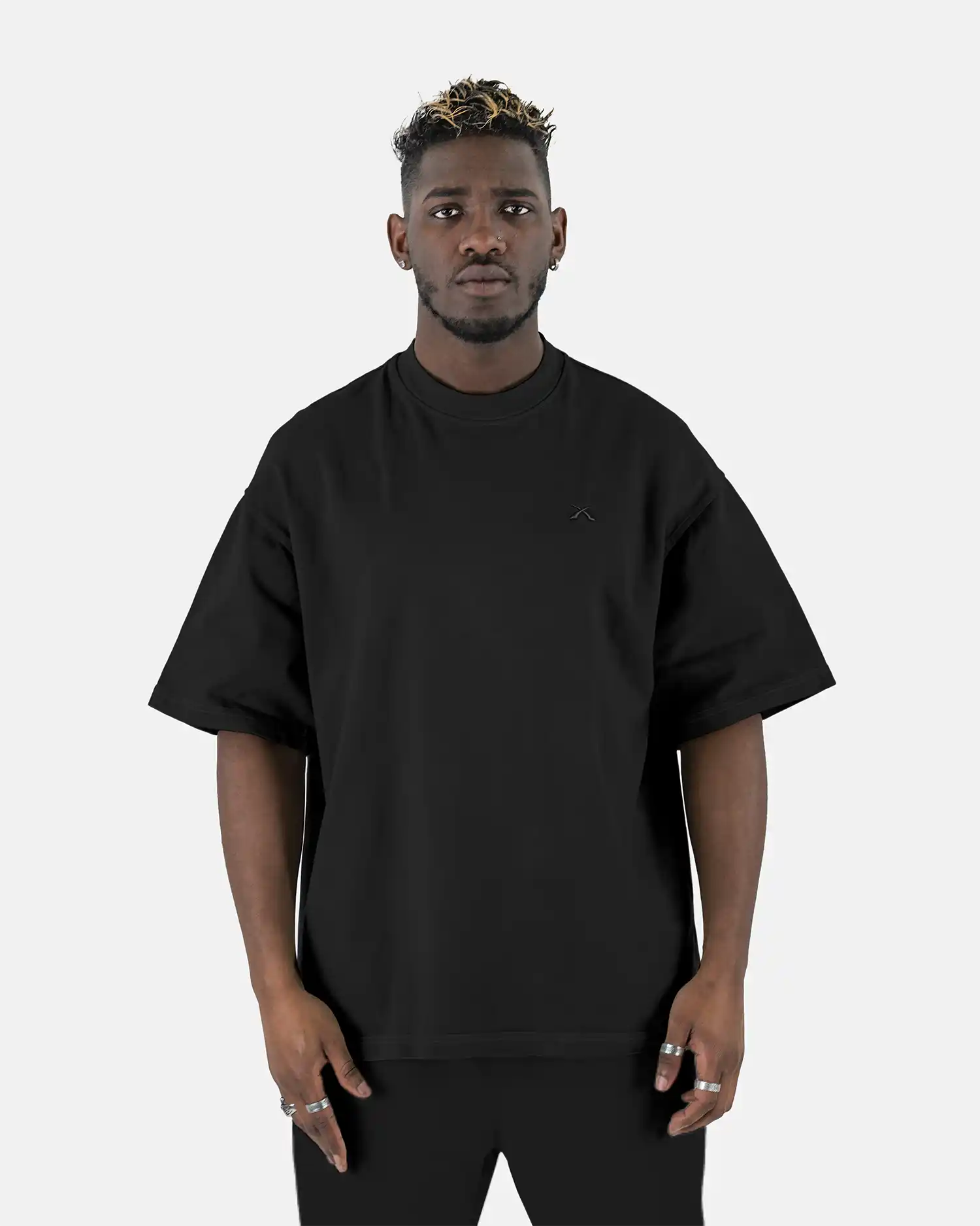 Vorderansicht eines Models, das das schwarze SQUEQO Oversized T-Shirt mit dezentem, Ton-in-Ton gesticktem Logo auf der Brust trägt.