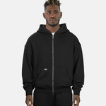 Model trägt SQUEQO Oversized Zip Hoodie in Schwarz