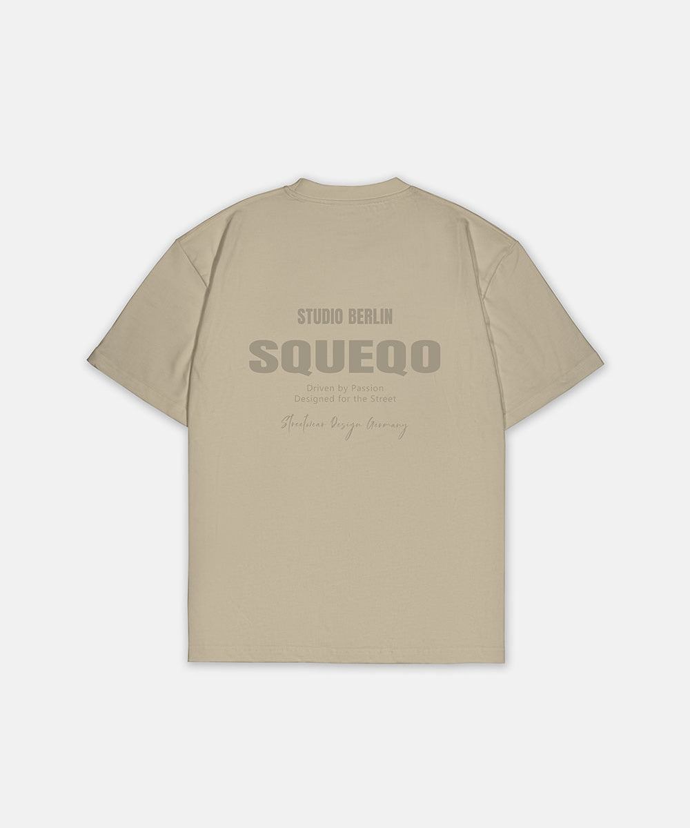 Beiges T-Shirt mit monochromem Studio Berlin SQUEQO Print auf der Rückseite.