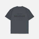 Graues T-Shirt mit monochromem Studio Berlin SQUEQO Print auf der Rückseite.