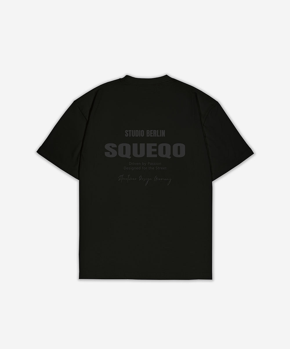 Schwarzes T-Shirt mit monochromem Studio Berlin SQUEQO Print auf der Rückseite.